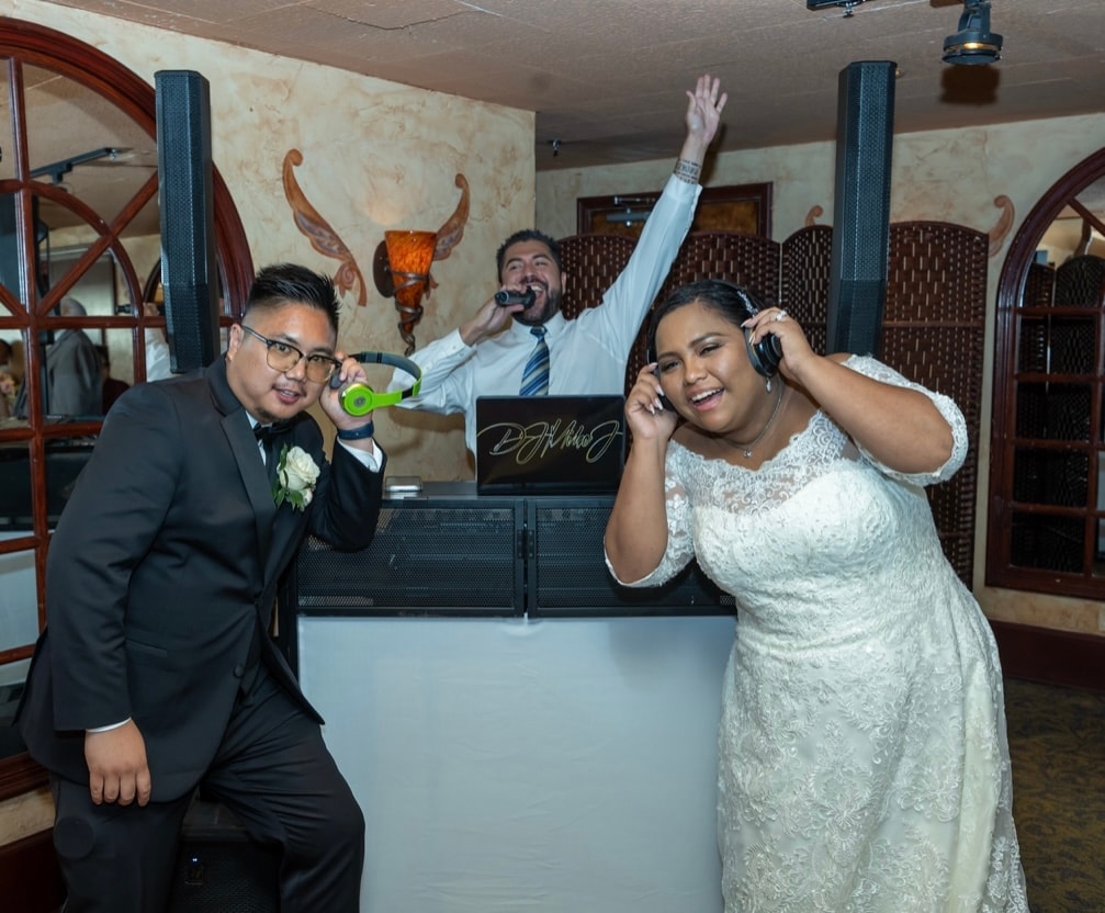 Bride and groom with green headphones at the DJ booth